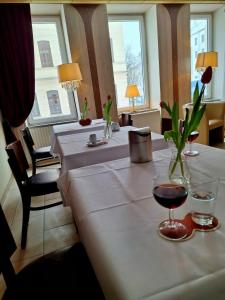 a table with two glasses of wine and flowers on it at Hotel mit zwei doppelzimmer in Leipzig