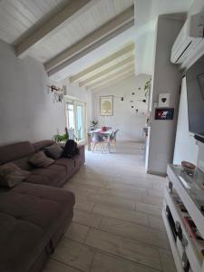 a living room with a couch and a table at Attico Casa ReGa - private parking and bbq in Quartu Sant'Elena