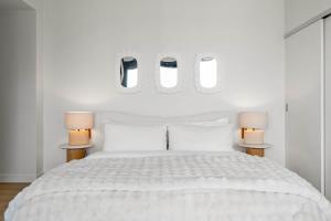 a white bedroom with a white bed with two lamps at Nuage 2 Bed 2 Bath 2 Balconies Parking in Calgary +18 photos