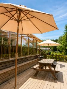 a picnic table and an umbrella on a deck at Nordic Home Finja in Hässleholm