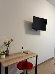 ein Zimmer mit einem Schreibtisch und einem Fernseher an der Wand in der Unterkunft Capizzi Rooms in Bronte + 5 Fotos