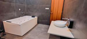 a bathroom with a bath tub and a sink at Wildexoticventure in Seonī