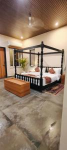 a bedroom with a black bed with a wooden frame at Wildexoticventure in Seonī