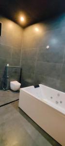 a bathroom with a white tub and a toilet at Wildexoticventure in Seonī