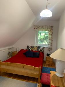 a bedroom with a red bed and a window at Artystycznie nad Bugiem 1 in Gnojno