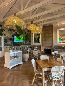 a dining room with tables and chairs and chandeliers at The Fairway Apartment in Plettenberg Bay