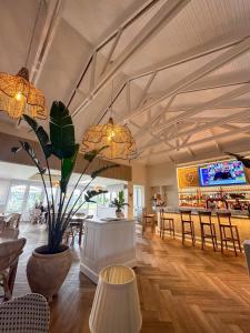 a lobby with tables and chairs and a restaurant at The Fairway Apartment in Plettenberg Bay