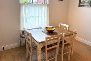 a dining room table with a bowl of fruit on it at Charming Lisburn Flat with private parking in Lisburn