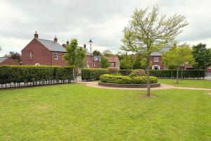 a park with a fence and houses in the background at Charming Lisburn Flat with private parking in Lisburn