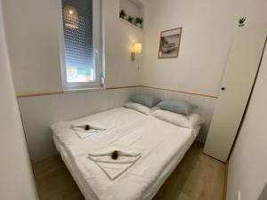 a small bed in a room with two pillows on it at Arany Toboz Vendégház in Siófok