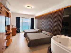 ein Hotelzimmer mit zwei Betten und einer Badewanne in der Unterkunft Suites Sol y Luna in Cancún
