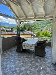 a patio with a table and chairs on a balcony at Vila jajcegrad in Jajce