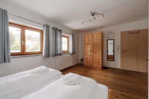 two beds in a room with two windows at Zimmer Zur Säge in Kötschach