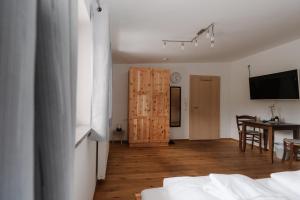 a room with a bed and a dining room with a table at Zimmer Zur Säge in Kötschach