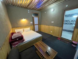 a small room with a bed and a table at Moon Lake Hotel, Nako in Nako