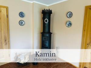 a black stove in a room with plates on the wall at VILLA SEEBERG - by "Schloss Gessenberg" luxurious vacation home with lake and mountain views, suitable for families and friends in Petting