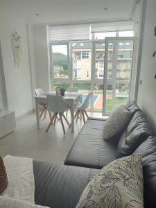 a living room with a couch and a table and chairs at Marzan Playa in Foz