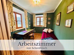 a green room with a desk and a couch at VILLA SEEBERG - by "Schloss Gessenberg" luxurious vacation home with lake and mountain views, suitable for families and friends in Petting
