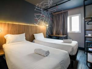 a hotel room with two beds with white sheets at ibis Curitiba Batel in Curitiba