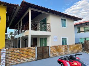 a red scooter parked in front of a house at El Shaday Suítes - ATÍNS in Atins