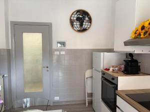 a kitchen with a refrigerator and a clock on the wall at I Tulipani in Genoa