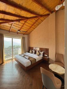a bedroom with a large bed and a large window at Ramasa Lake House in Bhīm Tāl
