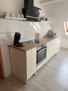 a kitchen with white cabinets and a stove top oven at Apartment 4 in Gera
