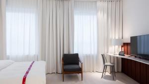 a hotel room with a bed and a tv and a chair at Ruby Marie Hotel Vienna by IHG in Vienna +85 photos