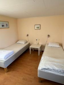 a room with two beds and a table in it at Sandby Pensionat in Löttorp