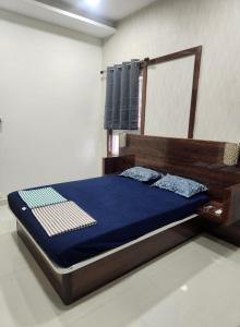 a bedroom with a bed with blue sheets and a mirror at Holiday Home Madurai - Duplex Villa Umachikulam in Madurai