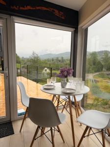 a table and chairs in a room with a large window at ArtMi in Lazeshchyna