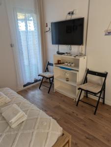 a bedroom with a tv and a bed and a chair at Balatonfenyvesparti kisház in Balatonfenyves +3 photos