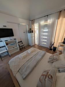 a bedroom with a large bed and a television at Balatonfenyvesparti kisház in Balatonfenyves