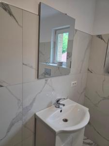 a white bathroom with a sink and a mirror at Happy Family in Suceviţa +52 photos