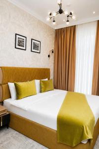 a bedroom with a large bed with yellow sheets at Delmar Boutique Buzovna in Mekhrably
