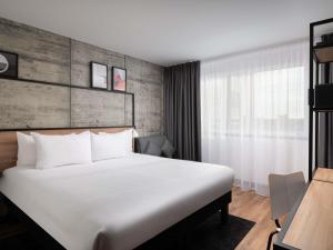 a hotel room with a large bed and a desk at ibis London Earls Court in London