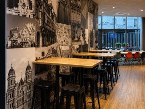 a row of tables and stools in a restaurant at Hotel ibis Dijon Centre Clemenceau in Dijon