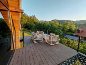 a deck with chairs and a table on a house at Shemoqmedi Chalet in Zemo Makvanetʼi