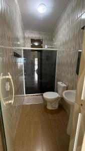a bathroom with a toilet and a sink at Pousada Amendoeira in Mangaratiba