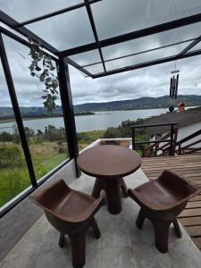 a table and two chairs on a balcony with a view at Benigno Mirador in Guatavita +34 photos