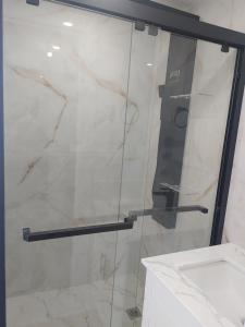 a shower with a glass door in a bathroom at Nigam's Sweet Home in Saint John +18 photos