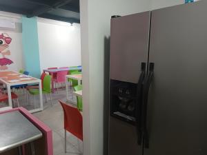 a kitchen with a refrigerator and tables and chairs at Suits hotel boutique in Nuevo Casas Grandes