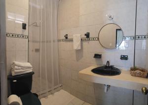 a bathroom with a sink and a mirror and a shower at Casa del Viento Celestun in Celestún +22 photos