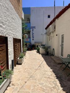 an alley between two buildings with a sign on a building at G&D guest house in Ancient Epidauros