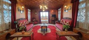 a living room with red furniture and a chandelier at Smith Palace Group Of Houseboats in Srinagar