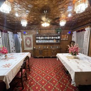 a dining room with two tables with flowers on it at Smith Palace Group Of Houseboats in Srinagar
