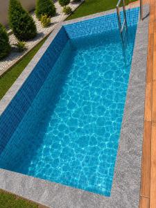 a swimming pool with blue water in a yard at Auravista in Pālghar +4 photos
