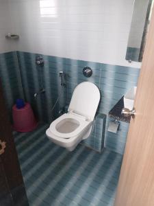 a bathroom with a toilet in a blue tiled bathroom at Auravista in Pālghar