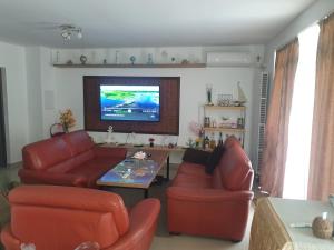 a living room with red furniture and a flat screen tv at Casa Tim in Tulcea