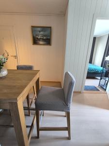 a dining room with a wooden table and a chair at Stavangerliving in Stavanger